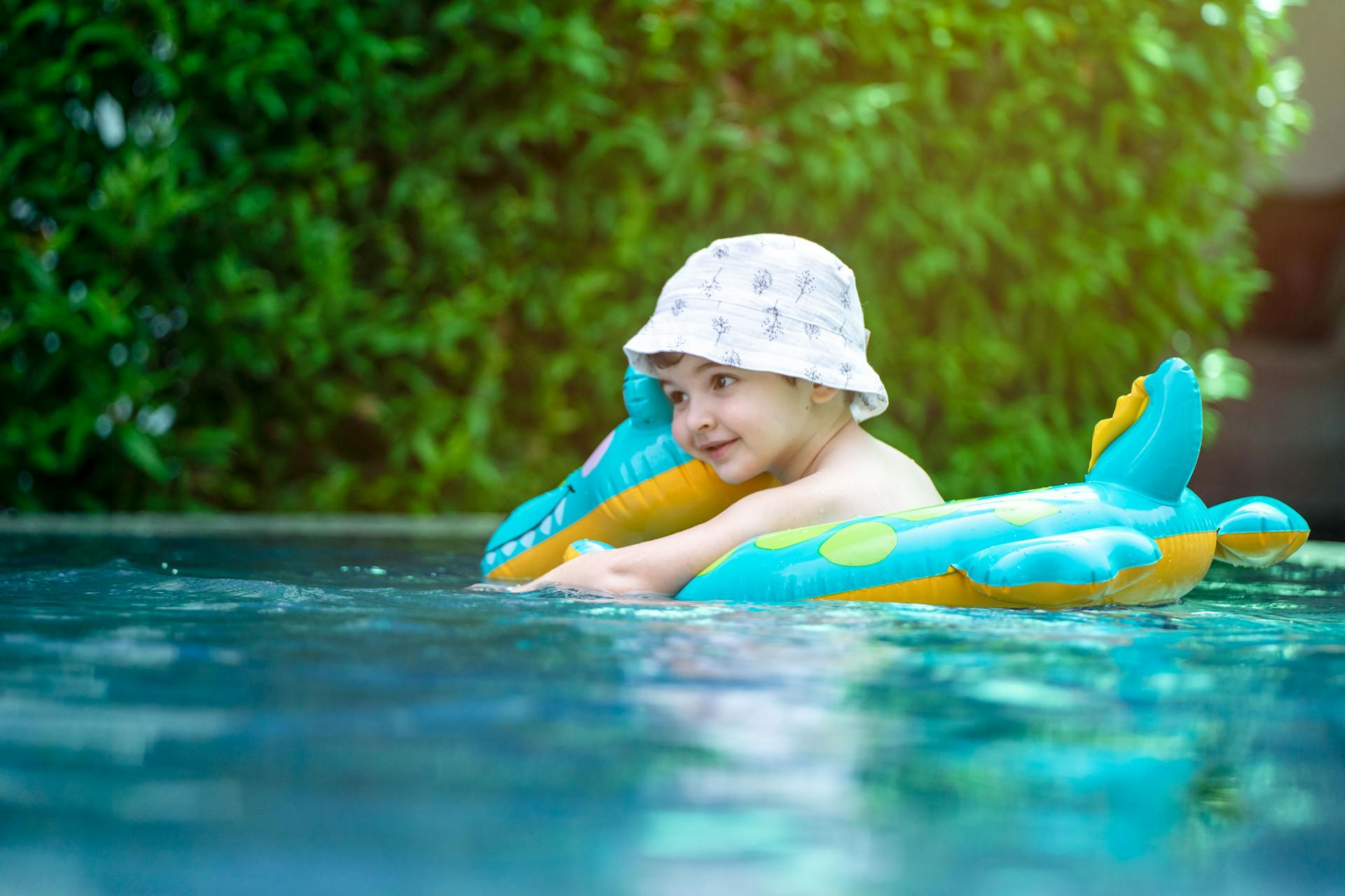 Young child in a home swimming pool with pool float