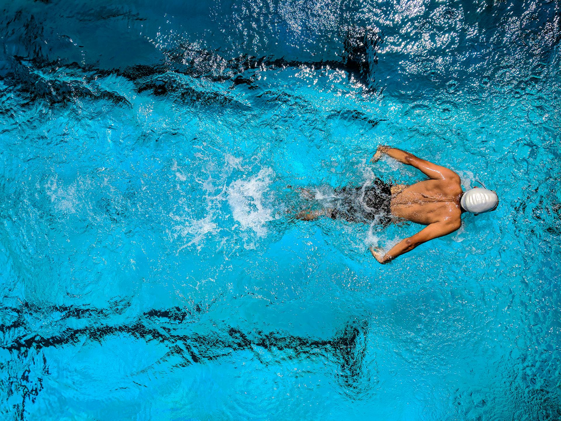 Man swimming in clean, maintained swimming pool.